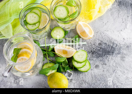 Zitrusfrüchte und Kräutern infundiert Sassi Wasser für Detox, gesundes Essen in Gläsern und Kanne auf über dunklen Hintergrund Stockfoto