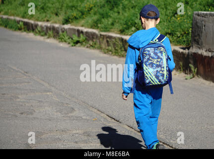 Junge kommt von der Schule nach Hause mit Rucksack Stockfoto