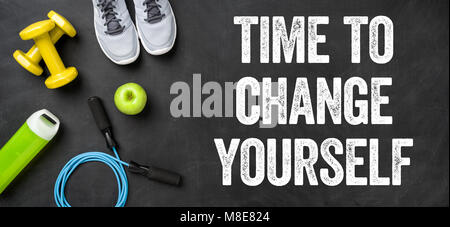 Fitnessgeräte auf dunklem Hintergrund - Zeit, sich selbst zu ändern. Stockfoto