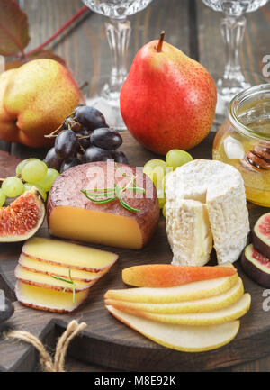 Der Käse mit Obst und Honig. Camembert. Bree. Trauben, Feigen, Birnen, und Rosmarin. Wein Snacks für Feinschmecker. Selektiver Fokus Stockfoto