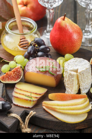 Der Käse mit Obst und Honig. Camembert. Bree. Trauben, Feigen, Birnen, und Rosmarin. Wein Snacks für Feinschmecker. Selektiver Fokus Stockfoto