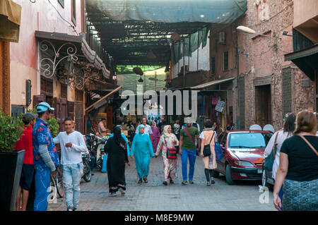 Einheimische und Touristen, die am späten Nachmittag einen Bummel durch den Souk in Sidi Abdelaziz in der Medina von Marrakesch, Marokko. Stockfoto