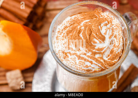 Pumpkin Spice latte Smoothie mit Schlagsahne und Zimt in Glas Schale auf Holz- Hintergrund. Traditionelle Herbst heiß oder kalt trinken. Country Style Stockfoto