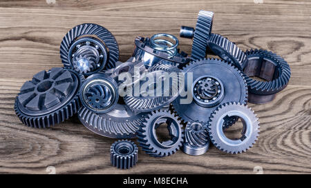 Haufen der verschiedenen Gänge auf Holz. Schöne Nahaufnahmen der Blau metallic Zahnräder auf der braunen Hintergrund. Konzept für die technische Industrie. Stockfoto