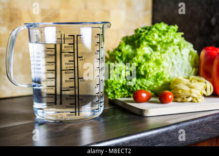 900ccm / 900ml Of Water In A Measuring Cup On A Kitchen Counter With Food Stockfoto