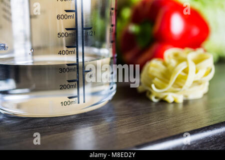 300ccm / 300ml Of Water In A Measuring Cup On A Kitchen Counter With Food Stockfoto
