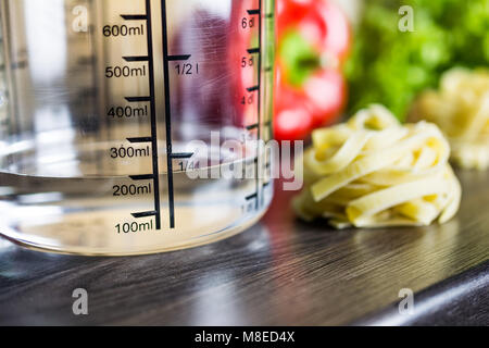 200ccm / 200ml Of Water In A Measuring Cup On A Kitchen Counter With Food Stockfoto