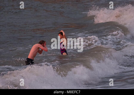 Aberystwyth Wales UK, Freitag, 16. März 2018 Deutschland Wetter: Am Ende eines milden Frühling am Nachmittag, eine junge Frau für eine braciung Abend geht in den Gewässern der Cardigan Bay schwimmen Aberystwyth an der Westküste von Wales das Met Office hat eine Reihe von Gelb und Gelb Warnungen für Schnee und Eis für das Wochenende, als Blast sehr kalte Luft bläst in aus dem Osten Foto © Keith Morris/Alamy leben Nachrichten Stockfoto