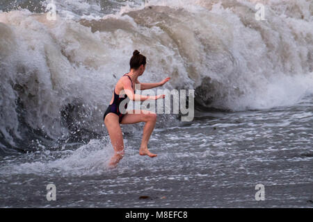 Aberystwyth Wales UK, Freitag, 16. März 2018 Deutschland Wetter: Am Ende eines milden Frühling am Nachmittag, eine junge Frau für eine braciung Abend geht in den Gewässern der Cardigan Bay schwimmen Aberystwyth an der Westküste von Wales das Met Office hat eine Reihe von Gelb und Gelb Warnungen für Schnee und Eis für das Wochenende, als Blast sehr kalte Luft bläst in aus dem Osten Foto © Keith Morris/Alamy leben Nachrichten Stockfoto