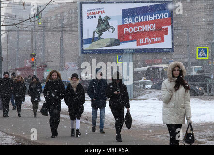 St. Petersburg, Russland. 17 Mär, 2018. Menschen gehen in der Nähe von einem wahlplakat Für den russischen Präsidenten Wladimir Putin in einer Straße in St. Petersburg. Quelle: Igor Russak/SOPA Images/ZUMA Draht/Alamy leben Nachrichten Stockfoto