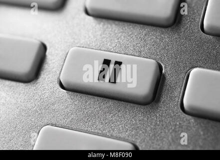 Nahaufnahme von einem grauen Pause Taste auf Chrom Fernbedienung für einen Hifi Stereo Audio System Stockfoto