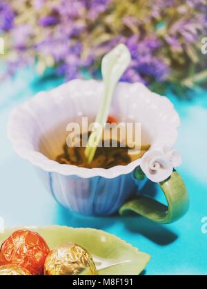 Handmade schöne Blume Tasse duftenden Kaffee violett Porzellan und Süßigkeiten Stockfoto