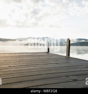 USA, New York, Lake Placid, Pier mit nebligen See im Hintergrund Stockfoto