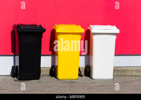 Drei farbige Papierkörbe auf der Straße/Schwarz/Gelb/Weiß Stockfoto