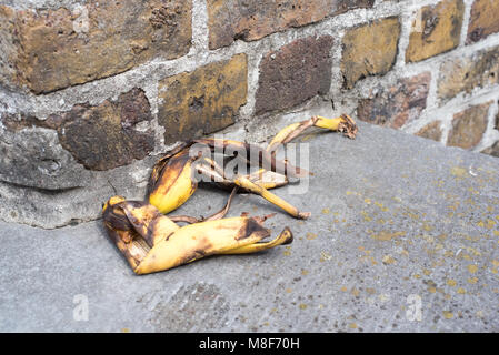 Alte Bananenschale gegen eine Wand in der Straße Stockfoto