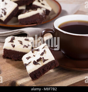 Zwei chocolate fudge Brownies mit einer Tasse Kaffee auf einer hölzernen Fach