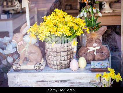 Ostern Thema im Schaufenster der einen Souvenirshop. Blumen, Spielzeug und Ostereier auf einen Jahrgang Brust Stockfoto