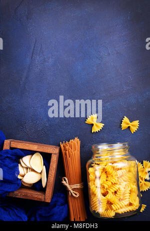 Verschiedene Arten von Pasta, rohe Nudeln auf einem Tisch Stockfoto
