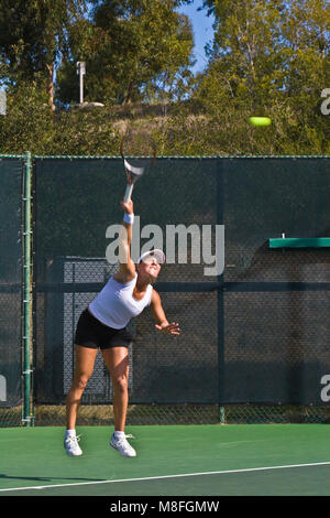 Anna Tatishvili in grauen Hemd und weißen Rock Tennis ball mit Schläger an sonnigen Green Court. Stockfoto