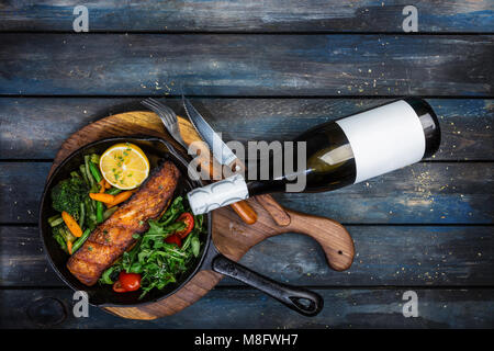 Gegrilltes Lachsfilet in einer Pfanne, Gemüse, Rucola mit Zitrone. Stockfoto