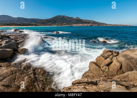 Slow Shutter Bild von Wellen auf die Felsen in der Nähe von Algajola Strand in der Balagne Korsika unter einem tiefblauen Himmel Stockfoto