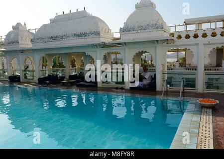 Inder spielen ein Rohr an der ruhigen Swimmingpool auf dem Dach eines Heritage Hotel udaipur Rajashan Indien Stockfoto