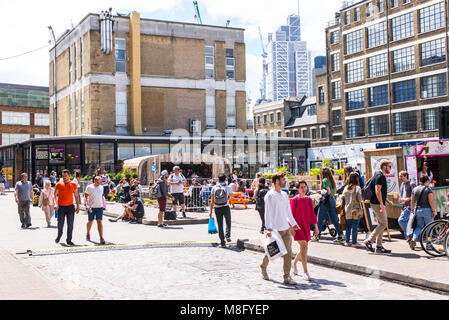 Die Menschen genießen die warmen Sommer in der Alten Truman Brauerei, Ely's Yard, Shoreditch, London, UK Stockfoto