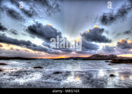 Isle of Mull, Schottland. Künstlerische Sonnenuntergang Blick von Fidden Strand an der Westküste von Mull, mit der Insel Iona im Hintergrund. Stockfoto