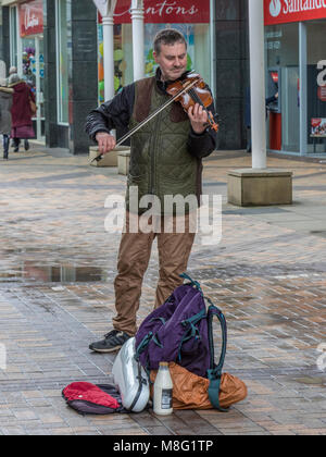 Straße Gaukler spielen Violine für Geldspenden in Stockport Stadtzentrum Einkaufszentrum, Merseyway Stockfoto