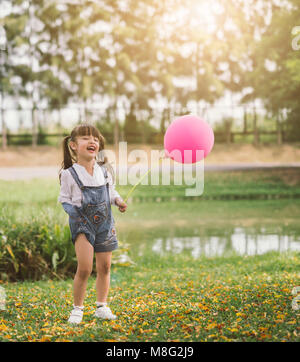 Portrait glückliche kleine Mädchen mit Ballon Spaziergänge im Park im Freien Stockfoto