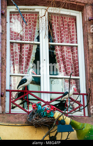 Land chic Fenster mit roten Vorhängen und Störche in Colmar, Elsass, Frankreich Stockfoto