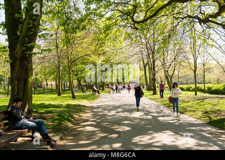 Menschen zu Fuß in einem sonnigen warmen Sommertag in Holland Park, London, UK Stockfoto