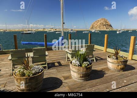 Holzterrassenrestaurant am Wasser mit Blick auf die Landschaft Morro Bay Harbour Rock, State Historic Pacific Coast Landmark am malerischen California Highway 1 Stockfoto