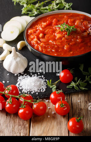 Italienische pizzaiola Sauce mit Tomaten, Oregano, Zwiebeln und Knoblauch in der Nähe - Auf den Tisch. Vertikale Stockfoto