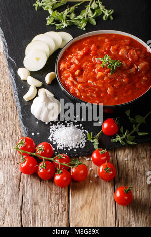 Italienische Sauce pizzaiola mit Zutaten close-up auf dem Tisch. Vertikale Stockfoto