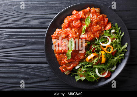 Steak carne alla pizzaiola und frisches Gemüse Salat close-up auf einem Teller auf den Tisch. horizontal oben Ansicht von oben Stockfoto