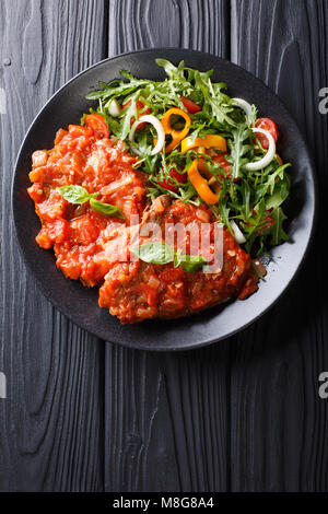 Steak carne alla pizzaiola und frisches Gemüse Salat close-up auf einem Teller auf den Tisch. Vertikal oben Ansicht von oben Stockfoto