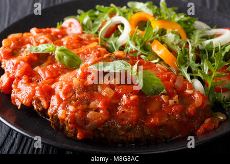 Steak carne alla pizzaiola und frisches Gemüse Salat close-up auf einem Teller auf den Tisch. Horizontale Stockfoto