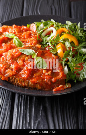 Steak mit Sauce pizzaiola und frisches Gemüse Salat close-up auf einem Teller auf den Tisch. Vertikale Stockfoto