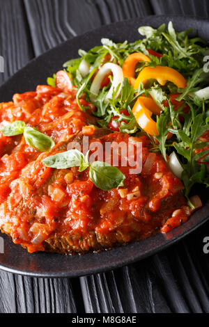 Rindersteak mit pizzaiola Sauce und frischen Salat close-up auf einem Teller. Vertikale Stockfoto