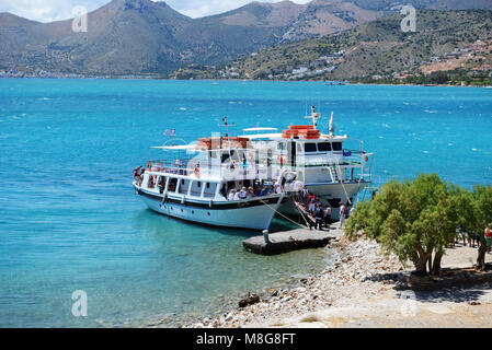 SPINALONGA, Griechenland - 14. Mai: Der Motor Yachten mit Touristen sind in der Nähe der Insel Spinalonga am 14. Mai in Spinalonga, Griechenland 2014. Bis zu 16 Millionen Touristen ist Stockfoto