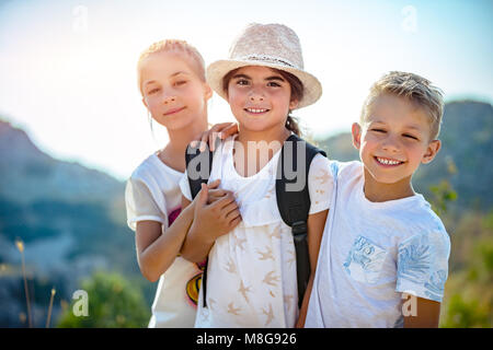 Porträt einer Drei glückliche Freunde im Freien, Geschwister mit Vergnügen, die zusammen reisen, Spaß haben im Sommer Camp, beste Freunde für immer Stockfoto