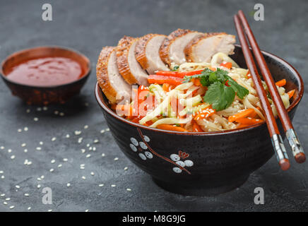 Udon Nudeln mit Gemüse (Karotten, Paprika, Zucchini, Gurken, Zwiebeln, Koriander, Knoblauch), Ente und Sesam. Der brj zu rühren. Selektiver Fokus Stockfoto