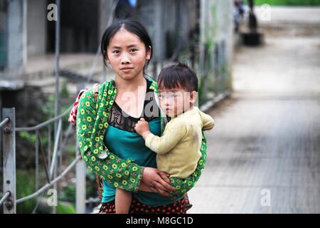 Ha Giang, Vietnam - 17. März 2018: die Mutter über eine Brücke mit einem Kind in einer ländlichen Gegend im Norden von Vietnam Stockfoto