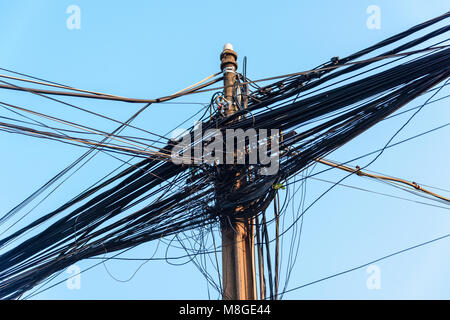 Strommast mit Dutzenden von gefährlichen ungepflegt unordentlich Kabel und Leitungen Stockfoto
