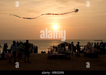 Die Menschen vor Ort und die Inhaber mit einem Drachen in der Luft auf Galle Face Green bei Sonnenuntergang Stall - ein beliebter Ort in Colombo Zeit am Meer zu verbringen. Stockfoto