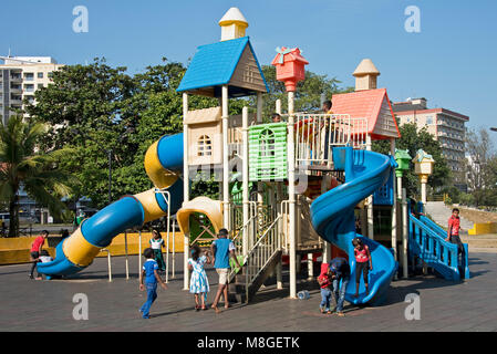 Kinder spielen auf dem Spielplatz des Viharamahadevi Park (Vihara maha Devi) an einem sonnigen Tag mit blauen Himmel. Stockfoto