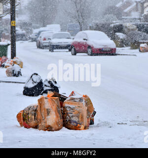 Winter street scene Beutel des Recycling von Abfällen und schwarzen Sack Deponie müll Schnee auf Pflaster für die Abfallwirtschaft Team collection Lkw UK abgedeckt Stockfoto