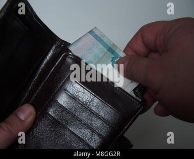 Eine Person zieht aus dem Geldbeutel Rechnung Nennwert von 1000 russischen Rubel. Close Up. Stockfoto