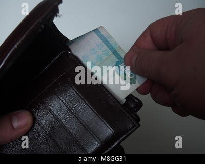 Eine Person zieht aus dem Geldbeutel Rechnung Nennwert von 1000 russischen Rubel. Close Up. Stockfoto